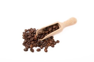 Beyaz arka planda izole edilmiş, tahta kaşıkta kahve çekirdekleri..