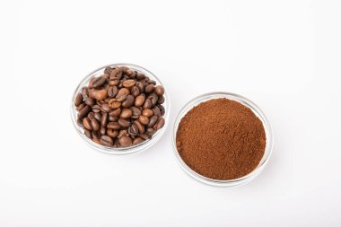 Bowl of ground coffee and beans isolated on a white background.