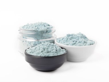Blue spirulina powder in bowls isolated on white background. Natural vegan superfood. Food supplement. Phycocyanin extract.