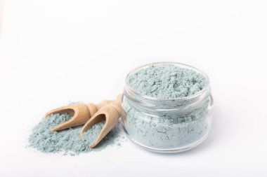 Blue spirulina powder in glass jar and spoon isolated on white background. Natural vegan superfood. Food supplement. Phycocyanin extract.