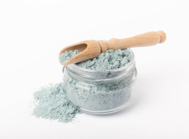 Blue spirulina powder in glass jar and spoon isolated on white background. Natural vegan superfood. Food supplement. Phycocyanin extract.