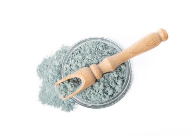 Blue spirulina powder in glass jar and spoon isolated on white background. Natural vegan superfood. Food supplement. Phycocyanin extract.