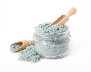 Blue spirulina powder in glass jar and spoon isolated on white background. Natural vegan superfood. Food supplement. Phycocyanin extract.