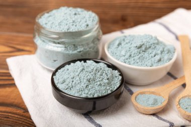 Blue spirulina powder in bowls on a brown table. Natural vegan superfood. Food supplement. Phycocyanin extract. Healthly food. Place for text. Copy space.