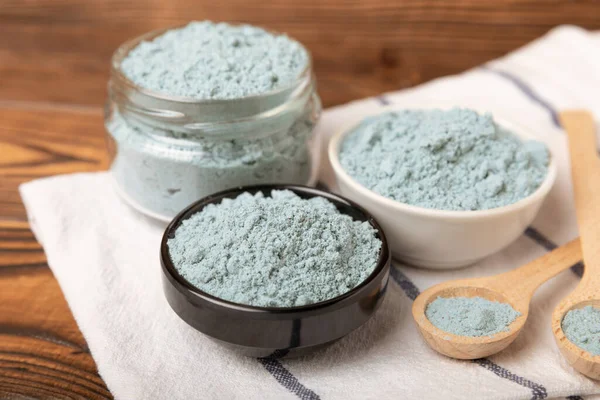 Blue spirulina powder in bowls on a brown table. Natural vegan superfood. Food supplement. Phycocyanin extract. Healthly food. Place for text. Copy space.