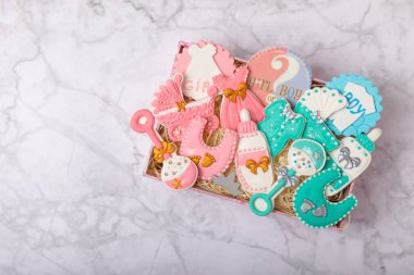 A set of baby shower cookies in a gift box on a marble background. Holiday concept. Baby party. View from above. Flat lay.