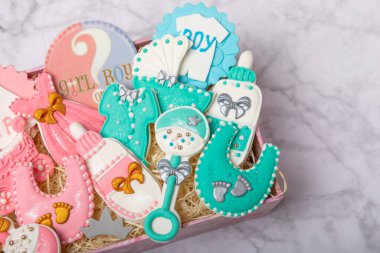 A set of baby shower cookies in a gift box on a marble background. Holiday concept. Baby party. View from above. Flat lay.