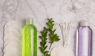 Micellar cleansing water and cotton pads on a marble background. Facial cleansing or makeup remover cosmetic bottle in bathroom. Skin care concepts. Cleansing the face of makeup and skin sebum.