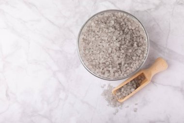 Sea salt in a bowl on a white marble background. Spice. Bath salt. Spa procedures. Skin care concept. Beauty