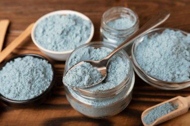 Blue spirulina powder in a glass jar on a brown background. Natural superfood, vegan, healthy food supplement. Phycocyanin extract. Antioxidant. Place for text. Copy space.