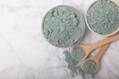 Blue spirulina powder in jars, bowls and spoons on a marble background. Natural superfood, vegan, healthy food supplement. Phycocyanin extract. Antioxidant. Place for text. Copy space.