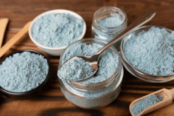 Blue spirulina powder in a glass jar on a brown background. Natural superfood, vegan, healthy food supplement. Phycocyanin extract. Antioxidant. Place for text. Copy space.