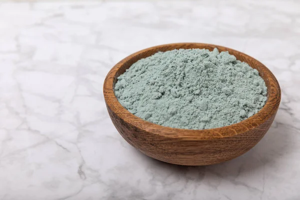 Blue spirulina powder in a bowl on a white marble background. Natural superfood, vegan, healthy food supplement. Phycocyanin extract. Antioxidant. Place for text. Copy space.