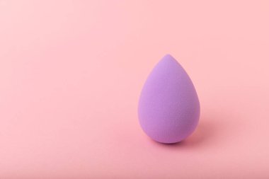 Pembe arka planda bir güzellik blenderi. Makyaj malzemesi olarak parlak süngerler. Makyaj ürünleri. Güzellik konsepti. Mesaj için yer. Kopya için yer var. Düz yatıyordu