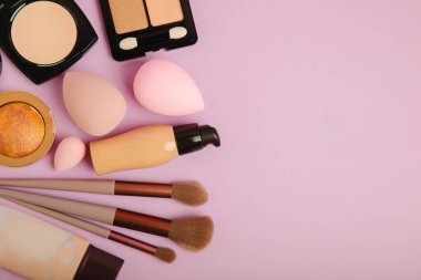 Beauty blender for applying bb cream or concealer and cosmetics on a bright colored background. Foundation, face powder, eye shadow, blush and lash mascara. Beauty concept. Fashion. Place for text.