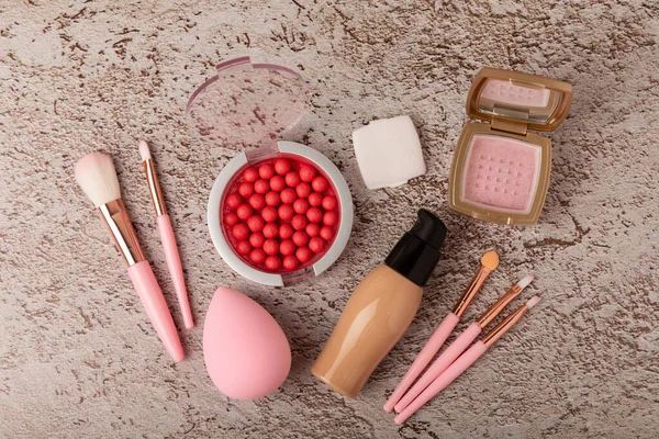 Beauty blender for applying bb cream or concealer and cosmetics on a marble background. Foundation, face powder, eye shadow, blush and lash mascara. Beauty concept. Fashion. Place for text.