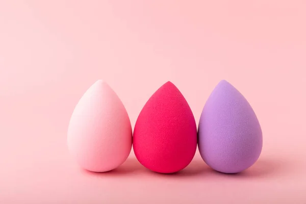 Beauty blender. Colorful beauty sponges on a pink background. Cosmetic tool for applying foundation, concealer. Place for text. Place to copy.