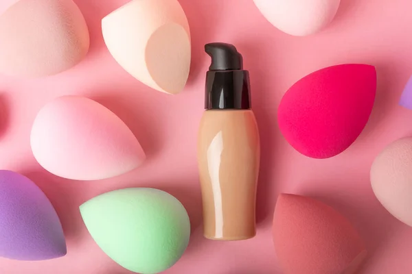 Beauty blender,bb cream or concealer on a colorful bright background.Liquid makeup base and makeup blender sponge. Foundation beauty face makeup application, perfect makeup tool.