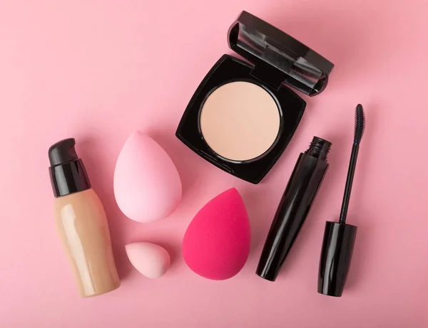 Beauty blender for applying bb cream or concealer and cosmetics on a bright colored background. Foundation, face powder, eye shadow, blush and lash mascara. Beauty concept. Fashion. Place for text.