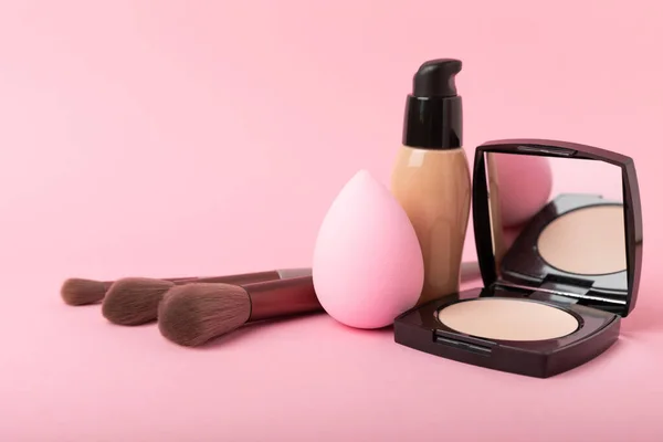 Beauty blender for applying bb cream or concealer and cosmetics on a bright colored background. Foundation, face powder, eye shadow, blush and lash mascara. Beauty concept. Fashion. Place for text.