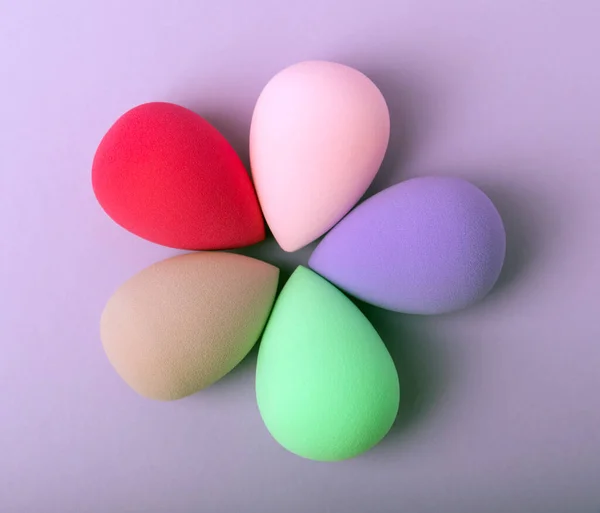 Beauty blender. Colorful beauty sponges on a lilac background. Cosmetic tool for applying foundation, concealer. Place for text. Place to copy.