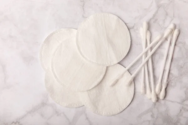 Cotton buds and cotton pads on a white marble background. Hygienic cotton swabs.Set of bamboo cotton buds. Biodegradable Cotton Buds for Ear.