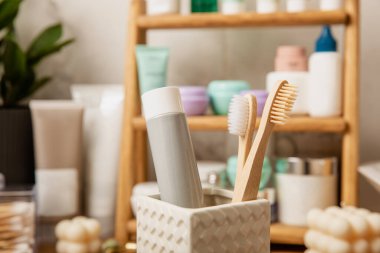 Eco bamboo toothbrushes and toothpaste tube mockup in the bathroom. Toothbrushes on the background of cosmetics on the shelf. Beauty concept. Dental car.