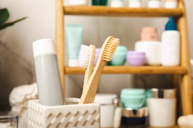 Eco bamboo toothbrushes and toothpaste tube mockup in the bathroom. Toothbrushes on the background of cosmetics on the shelf. Beauty concept. Dental car.