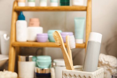 Eco bamboo toothbrushes and toothpaste tube mockup in the bathroom. Toothbrushes on the background of cosmetics on the shelf. Beauty concept. Dental car.