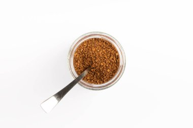 Soluble coffee grains in a glass jar isolated on a white background.