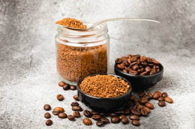 Ingredients for making coffee - coffee beans, ground and instant coffee on a black textured background. Caffeine. Decaffeinated coffee. Aroma energy hot drink. Place for text, space for copy.