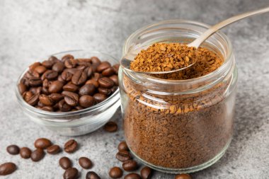 Ingredients for making coffee - coffee beans, ground and instant coffee on a black textured background. Caffeine. Decaffeinated coffee. Aroma energy hot drink. Place for text, space for copy.
