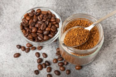Ingredients for making coffee - coffee beans, ground and instant coffee on a black textured background. Caffeine. Decaffeinated coffee. Aroma energy hot drink. Place for text, space for copy.