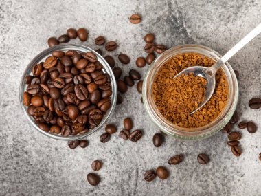 Ingredients for making coffee - coffee beans, ground and instant coffee on a black textured background. Caffeine. Decaffeinated coffee. Aroma energy hot drink. Place for text, space for copy.