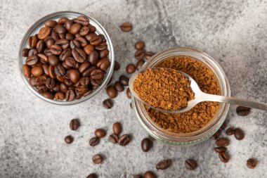 Ingredients for making coffee - coffee beans, ground and instant coffee on a black textured background. Caffeine. Decaffeinated coffee. Aroma energy hot drink. Place for text, space for copy.