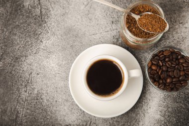 Ingredients for making coffee - coffee beans, ground and instant coffee on a black textured background. Caffeine. Decaffeinated coffee. Aroma energy hot drink. Place for text, space for copy.