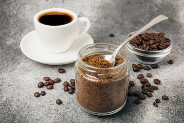 Ingredients for making coffee - coffee beans, ground and instant coffee on a black textured background. Caffeine. Decaffeinated coffee. Aroma energy hot drink. Place for text, space for copy.