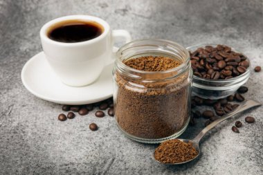 Ingredients for making coffee - coffee beans, ground and instant coffee on a black textured background. Caffeine. Decaffeinated coffee. Aroma energy hot drink. Place for text, space for copy.