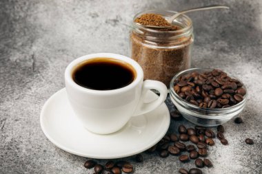 Ingredients for making coffee - coffee beans, ground and instant coffee on a black textured background. Caffeine. Decaffeinated coffee. Aroma energy hot drink. Place for text, space for copy.