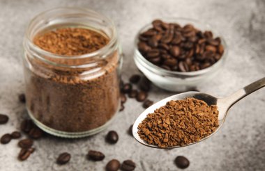 Ingredients for making coffee - coffee beans, ground and instant coffee on a black textured background. Caffeine. Decaffeinated coffee. Aroma energy hot drink. Place for text, space for copy.