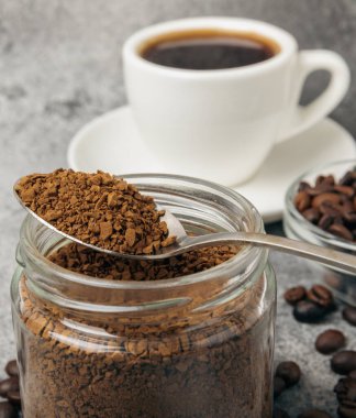 Ingredients for making coffee - coffee beans, ground and instant coffee on a black textured background. Caffeine. Decaffeinated coffee. Aroma energy hot drink. Place for text, space for copy.