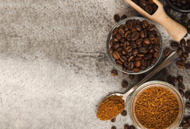 Ingredients for making coffee - coffee beans, ground and instant coffee on a black textured background. Caffeine. Decaffeinated coffee. Aroma energy hot drink. Place for text, space for copy.