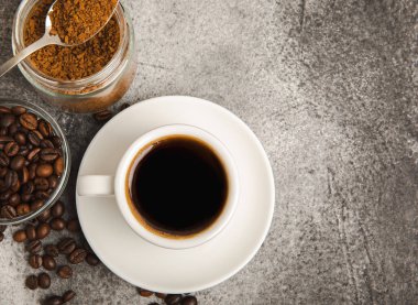 Ingredients for making coffee - coffee beans, ground and instant coffee on a black textured background. Caffeine. Decaffeinated coffee. Aroma energy hot drink. Place for text, space for copy.