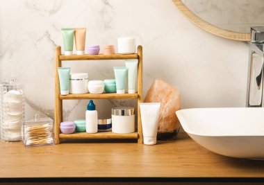 Sağlıklı cilt bakımı - serum ve yüz losyonu, vücut kremi, fırçalama, soyma ve temizleme, banyonun arka planında. Güzellik ve kozmetik konsepti. Ahşap bir rafta bir takım kozmetik ürünler..