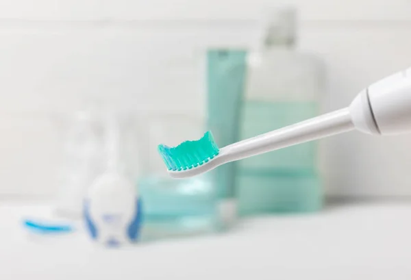 Electronic Ultrasonic Toothbrush Mouthwash Floss Tongue Cleaner Toothpaste White Wooden — Stock Photo, Image