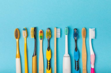 Renkli arka planda elektrikli, bambu ve sıradan diş fırçaları. Ağız temizliği. Çevre. Taşıyıcıların önlenmesi. Dişçi arabası. Diş hekimliği ve çevre dostu yaşam tarzı kavramı..