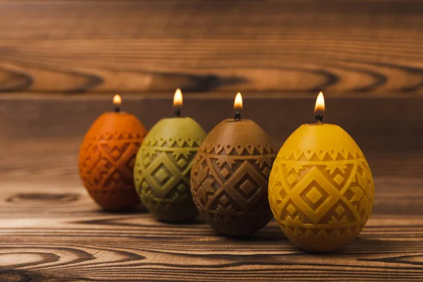 Easter candle eggs on brown texture background. Easter holiday concept.Spring willow bouquet.Decor for home and festive steel.Copy space. Place for text.