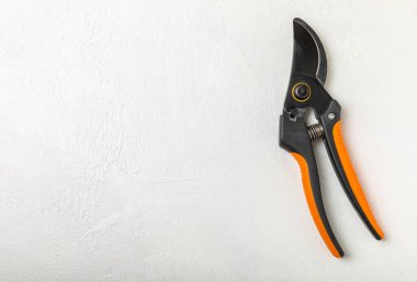 Beton arka planda yeni turuncu bahçe budayıcıları. Güzel manzara. Bahçe aletleri. Bahçe işleri ya da ekme konsepti. Bahar bahçesinde çalışıyorum. Yazı için yer var..