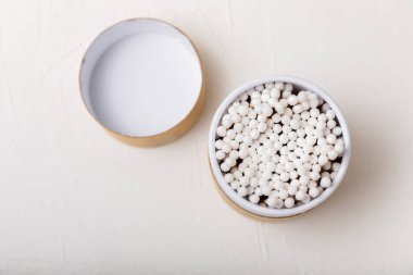 Hafif beton zeminde pamuk tomurcukları. Çevre dostu malzemeler. Tahta, beyaz bir zeminde pamuk örnekleri. Bambu bezleri ve pamuk çiçekleri. Sıfır atık, plastiksiz yaşam tarzı..