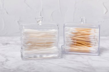 Hafif beton zeminde pamuk tomurcukları. Çevre dostu malzemeler. Tahta, beyaz bir zeminde pamuk örnekleri. Bambu bezleri ve pamuk çiçekleri. Sıfır atık, plastiksiz yaşam tarzı..